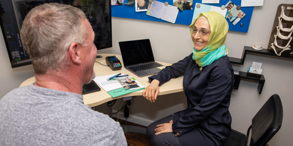 dental assistant discussing dental implantoptions with dental patient