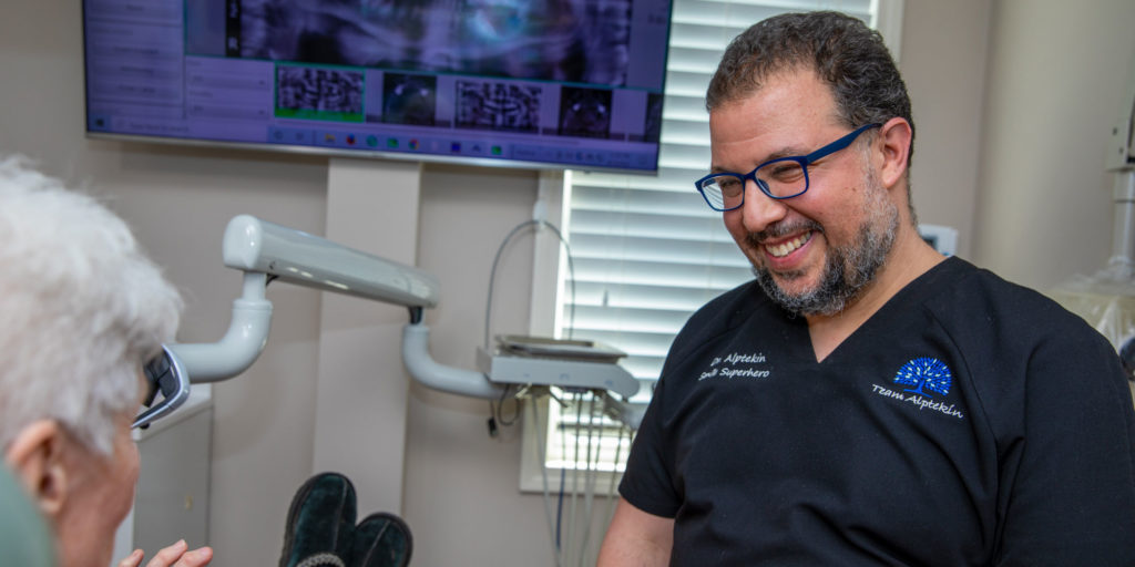 dr alptekin smiling with dental patient after procedure